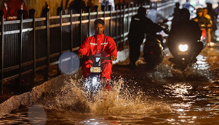 A delivery person rides an electric scooter in a waterlogged subway after heavy rains in Mumbai, India, July 8, 2024. — Reuters