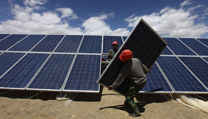 Workers install solar panels in a residential area. — Reuters/File