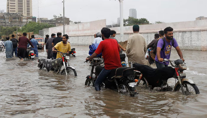 Residents commute through a flooded road during the monsoon season in Karachi, on July 9, 2022. — Reuters