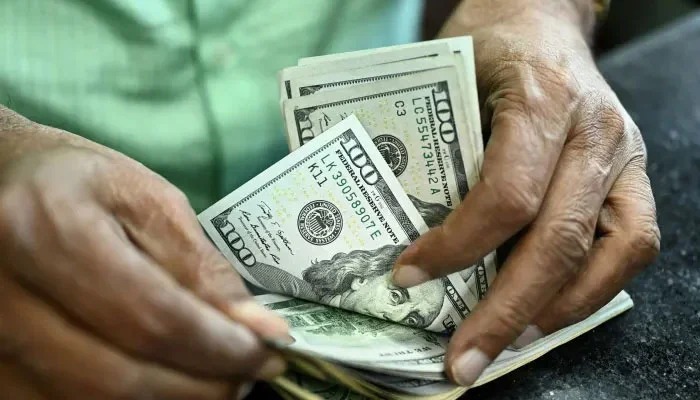 A man counts US dollars in a money exchange in Karachi. — AFP/File