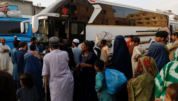 Afghan people gather to board a bus to return home, after Pakistan gave the last warning to undocumented migrants to leave, at a bus stop in Karachi, Pakistan October 25, 2023. — Reuters