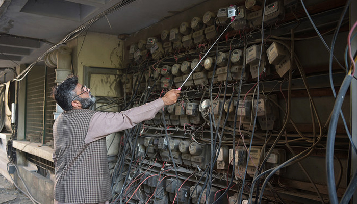 In this file photo taken on November 7, 2018, an Iesco employee takes a meter reading with his smartphone at a commercial building in Islamabad. — AFP