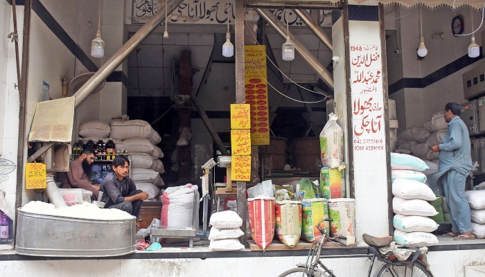 Shopkeeper sits on his flour shop waiting for customer in the Lahore on July 10, 2024. —Online