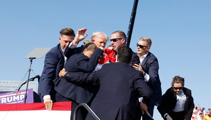 Republican presidential candidate former President Donald Trump is rushed offstage during a rally on July 13, 2024 in Butler, Pennsylvania. — AFP