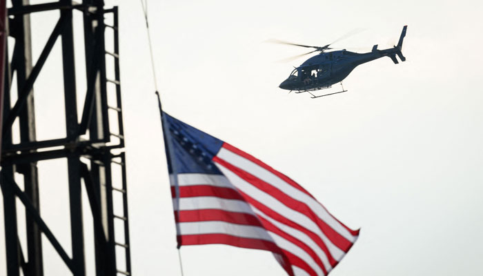 A helicopter hovers over the Fiserv Forum, site of the upcoming Republican National Convention, on July 13, 2024 in Milwaukee, Wisconsin. — AFP