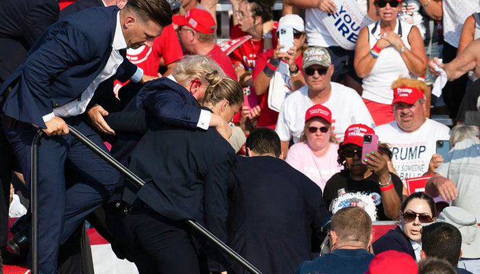 Republican candidate Donald Trump is seen with blood on his face surrounded by secret service agents as he is taken off the stage at a campaign event at Butler Farm Show Inc. in Butler, Pennsylvania, July 13, 2024. — AFP