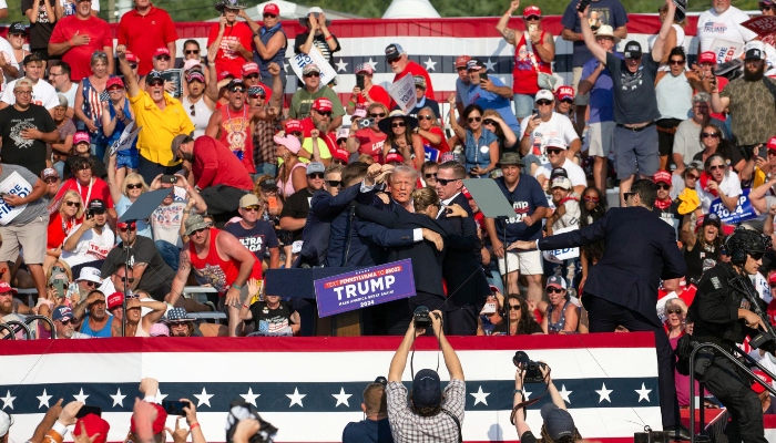 Republican candidate Donald Trump is seen with what appears to be blood on his face surrounded by secret service agents as he is taken off the stage at a campaign event at Butler Farm Show in Butler, Pennsylvania, on July 13, 2024. —AFP