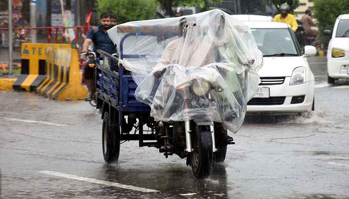 Commuters make their way through heavy monsoon rain in Lahore on July 12, 2024. — Online