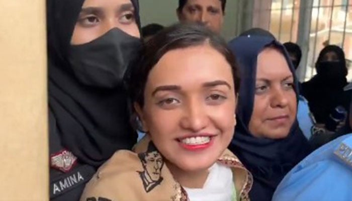 PTIs Sanam Javaid can be seen smiling while being taken for court hearing on July 15, 2024 in Islamabad. — X/@MurtazaViews