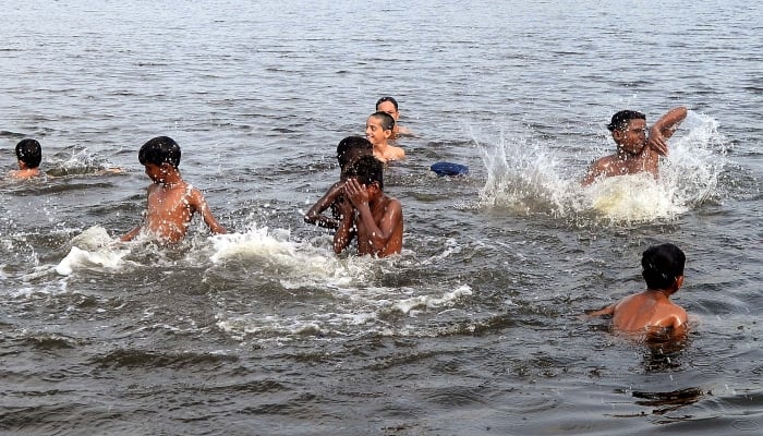 Youngsters enjoying bath into seawater to beat the heat during the hot weather, nearby Native Jetty Bridge in Karachi on July 1, 2024. —PPI