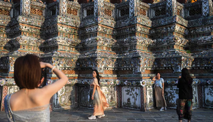 Tourists from mainland China dressed in traditional Thai costumes visit Wat Arun temple ahead of the Chinese Lunar New Year as China reopens the border in Bangkok, Thailand January 18, 2023. — Reuters