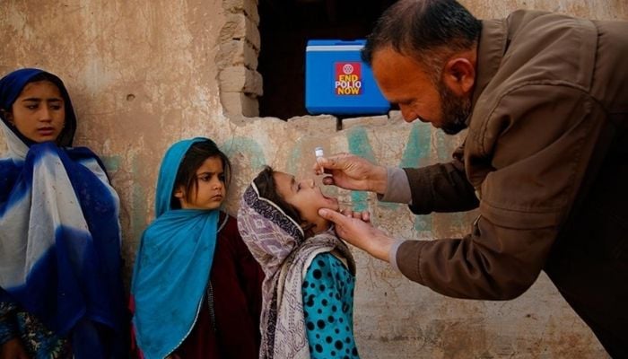 Health worker giving polio drops to a child in a city of Khyber Pakhtunkhwa. — UNICEF/ File