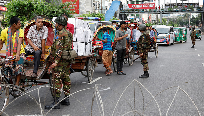 Members of the Bangladesh Army speak with people who came out on roads during a curfew imposed in response to student-led protests against government job quotas, in Dhaka, Bangladesh, July 20, 2024. — Reuters