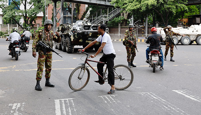 Members of the Bangladesh Army gesture to commuters on the second day of curfew, as violence erupted in parts of the country after protests by students against government job quotas, in Dhaka, Bangladesh, July 21, 2024. — Reuters