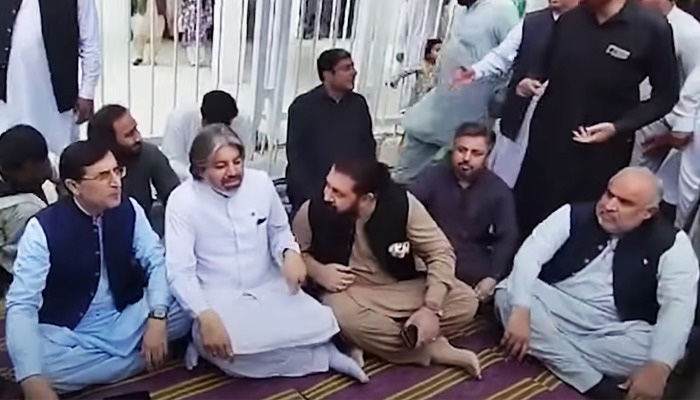 PTI Chairman Barrister Gohar Ali Khan (left) sitting at the hunger strike camp outside Parliament House, Islamabad, alongside other party leaders on July 23, 2024. — Screengrab via Geo News