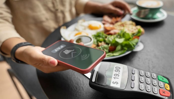 Representational image of a diner making a POS payment at an eatery. —Unsplash