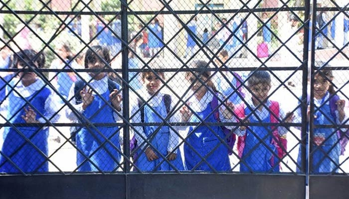 Schoolgirls are waiting for their parents after school timing in Islamabad on May 10, 2023. — Online