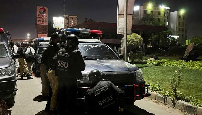 Police officers take position after a police office building was attacked by gunmen in Karachi on February 17, 2023. — Reuters