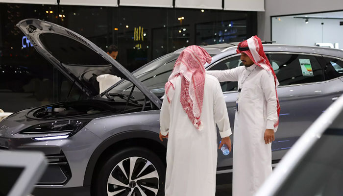 A customer is attended by a salesperson in an EV car show room in Saudi Arabia. — AFP