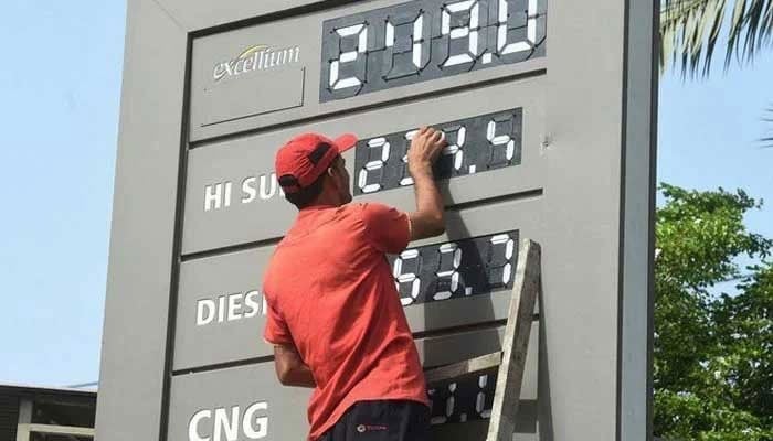 A petrol pump worker changing the price of petroleum products in this undated picture. — AFP/File