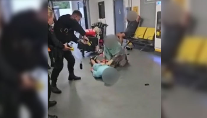 In this undated picture, a police officer is subjecting a man to torture at the Manchester Airport. —BBC/screengrab