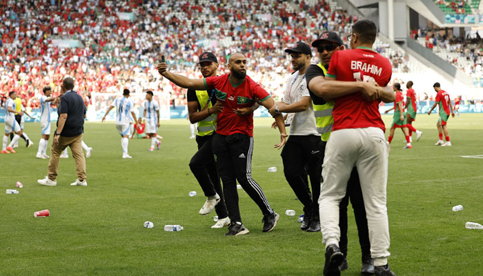 Pitch invaders are detained by stewards after the match at the Paris 2024 Olympics Mens Group B football match between Argentina and Morocco at Geoffroy-Guichard Stadium, Saint-Etienne, France on July 24, 2024. — Reuters