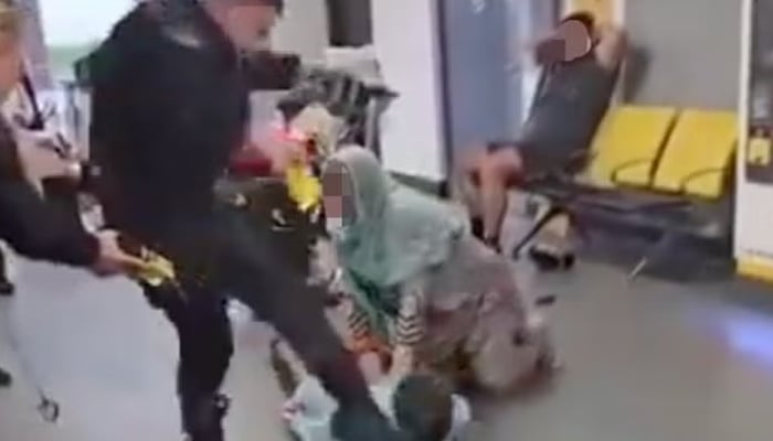 A police officer beats a young man at the Manchester Airport. — Social media