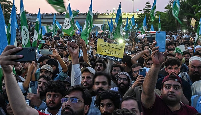 Activists and supporters of Jamaat-e-Islami (JI) shout slogans and wave their party flag to protest against rising inflation in Islamabad on July 26, 2024.