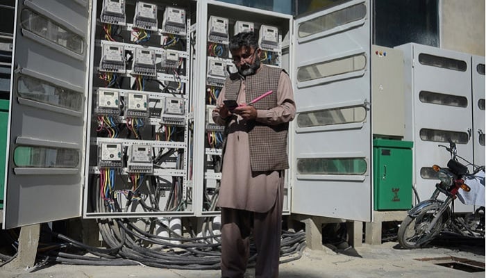 An employee of state-run Islamabad Electric Supply Company (IESCO), takes a meter reading with his smartphone at a commercial building in Islamabad on November 7, 2018. —AFP