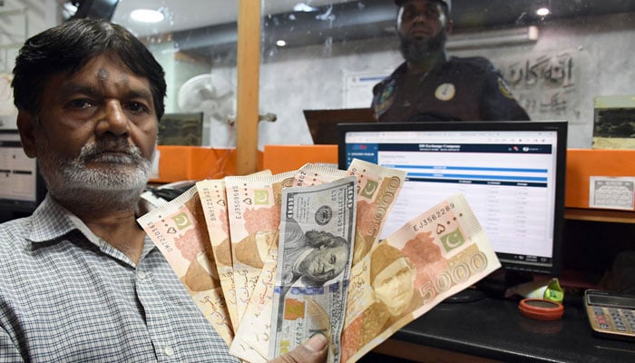 A foreign currency dealer counts US dollars at a shop in Karachi on March 2, 2023. — Online