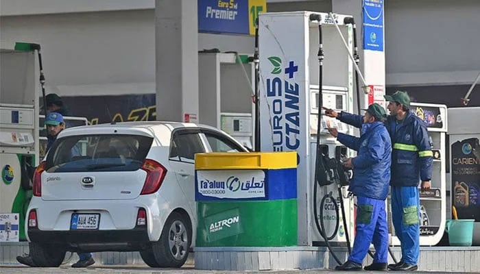 Employees at a fuel station attend to their customers in Islamabad, Pakistan, on February 16, 2022. — AFP/File