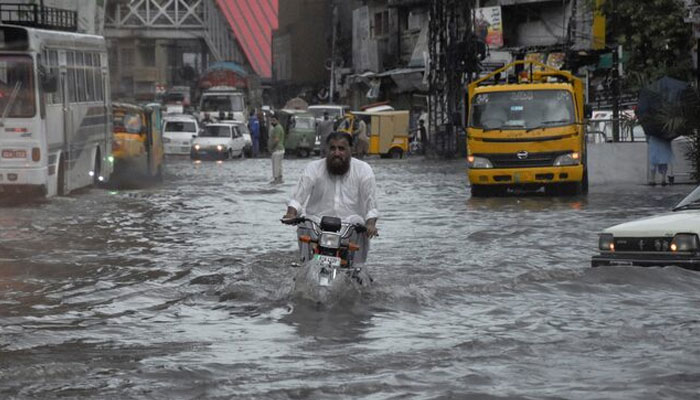 A man rides on a motorcycle amid flood waters along a road during the monsoon season in Rawalpindi, Pakistan July 19, 2023. — Reuters