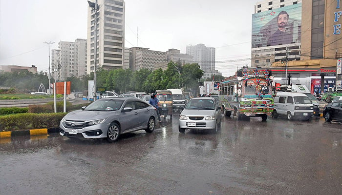 Commuters on their way at Karachi Press Club roundabout during rain in Karachi on July 30, 2024. — Online