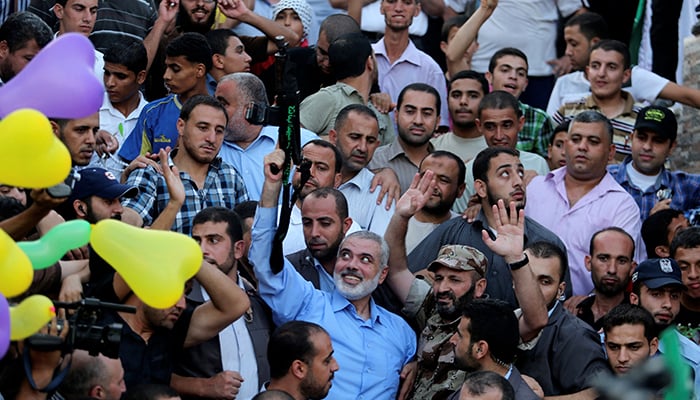 Hamas Gaza leader Ismail Haniyeh holds a gun as he appears for the first time since the start of a seven-week conflict during a rally by Palestinians celebrating what they said was a victory over Israel, in Gaza City August 27, 2014. — Reuters