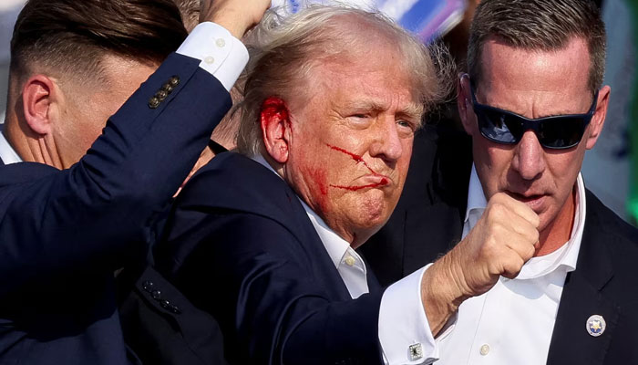 Former president of the US Donald Trump being escorted to safety by the Secret Service after an assassination attempt was carried out against him during a campaign rally in Butler, Pennsylvania, US on July 13, 2024. — Reuters