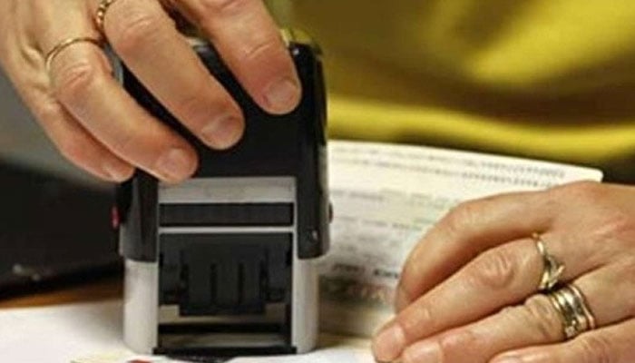 A representational image of a worker stamping a passport. — Reuters/File