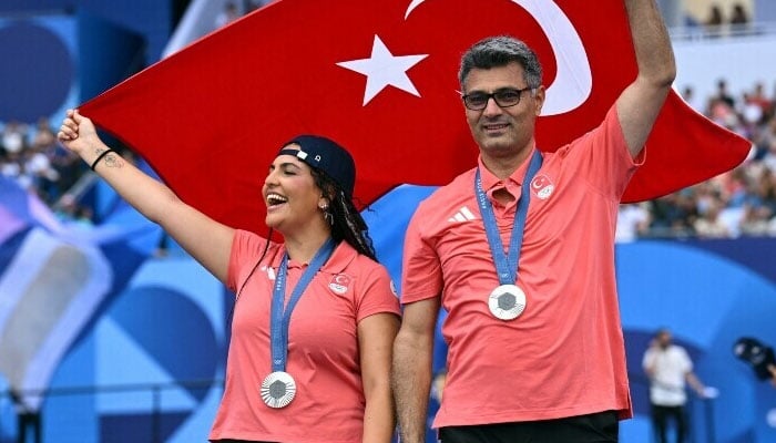 Shooting mixed silver medallists Sevval Ilayda Tarhan of Turkey and Yusuf Dikec of Turkey pose with their medals and the flag of Turkey during the Champions Park medallists celebrations in Paris, France on July 31. — Reuters