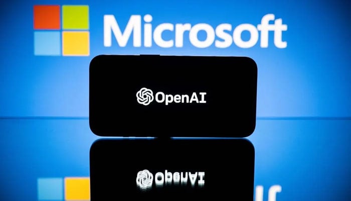 This image shows the OpenAI logo displayed on a phone screen against a screen with the the Microsoft logo on display. — AFP/File