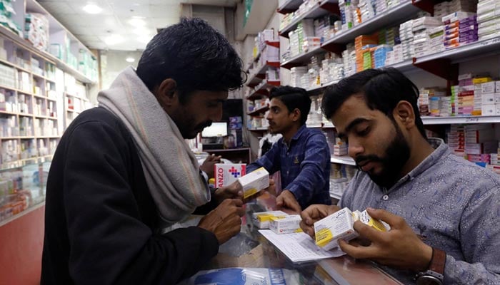 A customer buys medicine from a medical supply store in Karachi, February 9, 2023. — Reuters