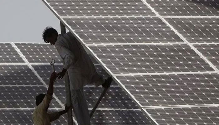 Technicians work on a solar panel at a power station about 25 km from Karachi June 18, 2010. — Reuters