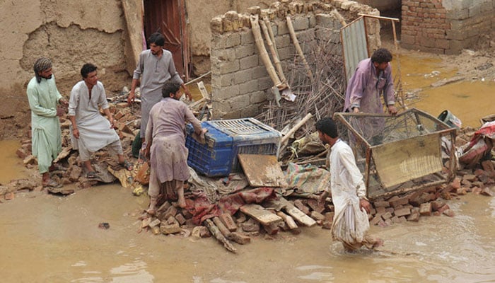 Residents clear debris of a damaged house due to a heavy monsoon rainfall on the outskirts of Quetta on July 5, 2022. — AFP