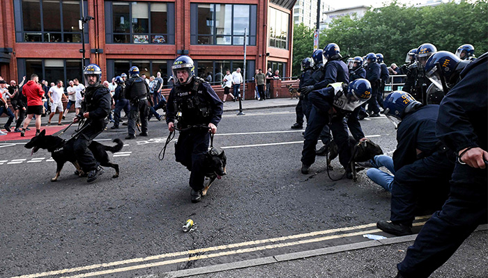 Police officers with dogs face protesters in Bristol, southern England, on August 3, 2024 during the ´Enough is Enough´ demonstration held in reaction to the fatal stabbings in Southport on July 29. — AFP