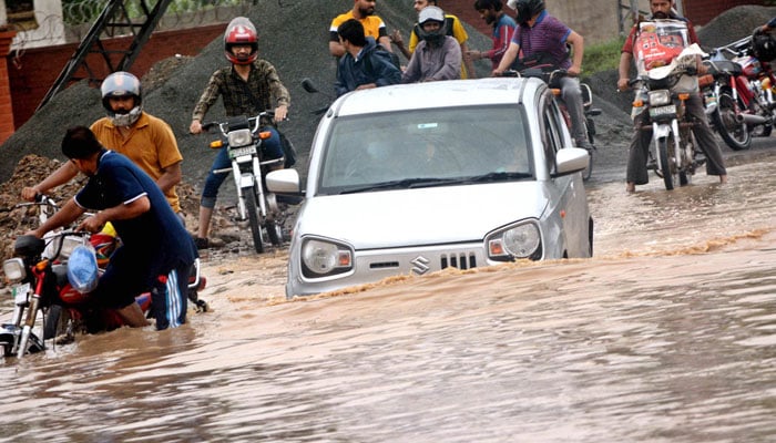 A car is trapped on a flooded road in Lahore following torrential rains that broke a 45-year record in the provincial capital on August 1, 2024. — APP