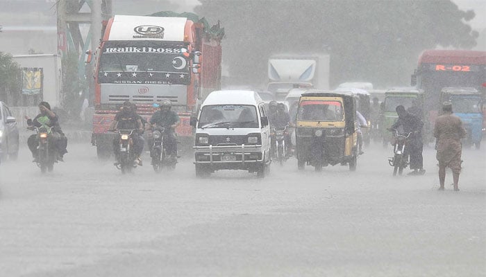 Commuters battle heavy rain on roads in Karachi on July 30, 2024. — INP