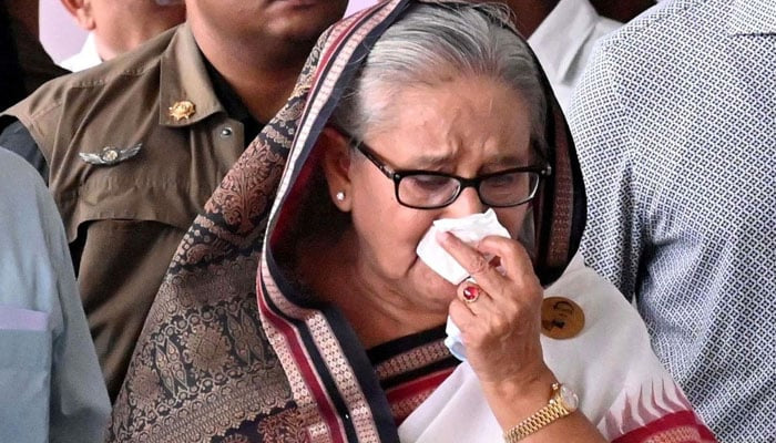 In this handout photograph taken and released on July 25, 2024 by Bangladesh Prime Minister´s Office, Prime Minister Sheikh Hasina (C) weeps while she visits a metro station in Mirpur vandalized by students during the anti-quota protests. — AFP