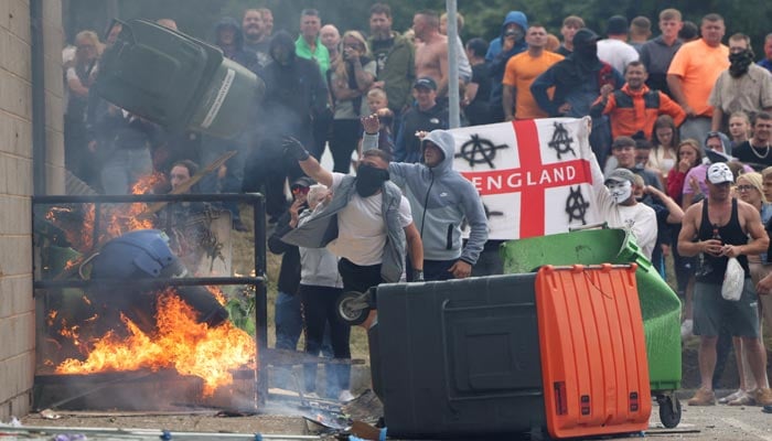 Demonstrators toss a trash bin during an anti-immigration protest, in Rotherham, Britain, August 4, 2024. — Reuters