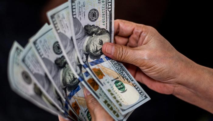 A person shows U.S. dollars at a currency exchange store in Manila, Philippines, October 21, 2022. — Reuters