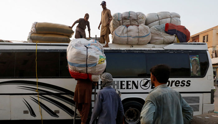 Passengers load their luggage on a bus at a bus terminal in Karachi. — Reuters/File