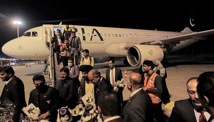 Passengers disembark off a Pakistan International Airlines Airbus A320 aircraft after landing on the tarmac at Najaf International Airport which serves Iraqs central holy shrine city on October 30, 2021. — AFP