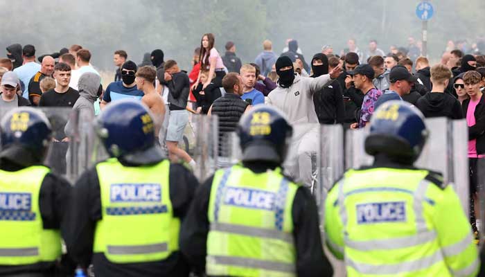 Police officers stand opposite to demonstrators during an anti-immigration protest, in Rotherham, Britain, August 4, 2024. — Reuters